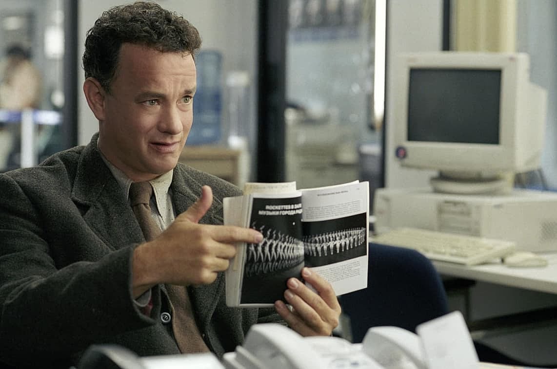 Tom Hanks holding a booklet for a scene of The Terminal