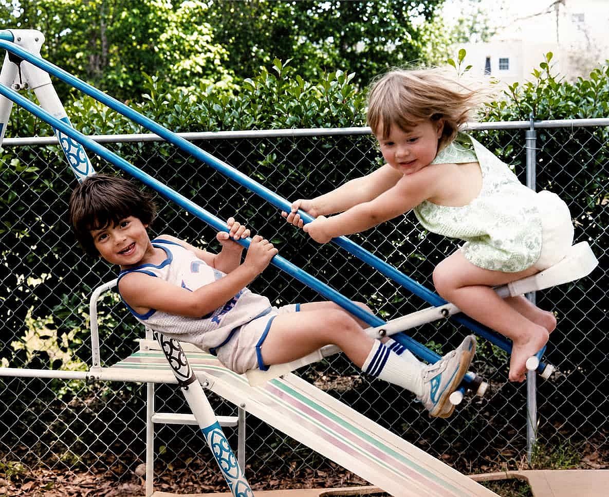 Siblings playing on the swing un 1982.