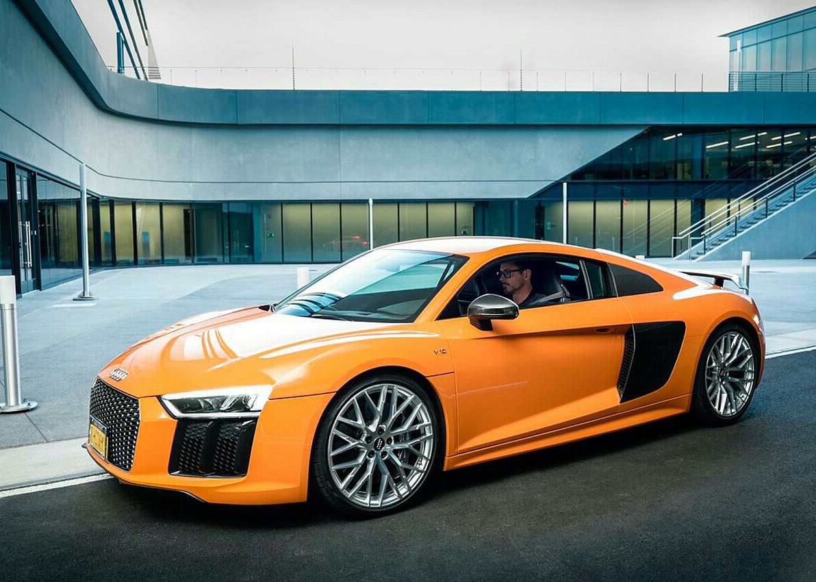Robert Downey Jr. in an orange Audi sports car.