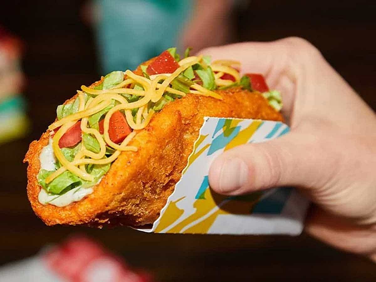 A hand holding a naked chicken chalupa