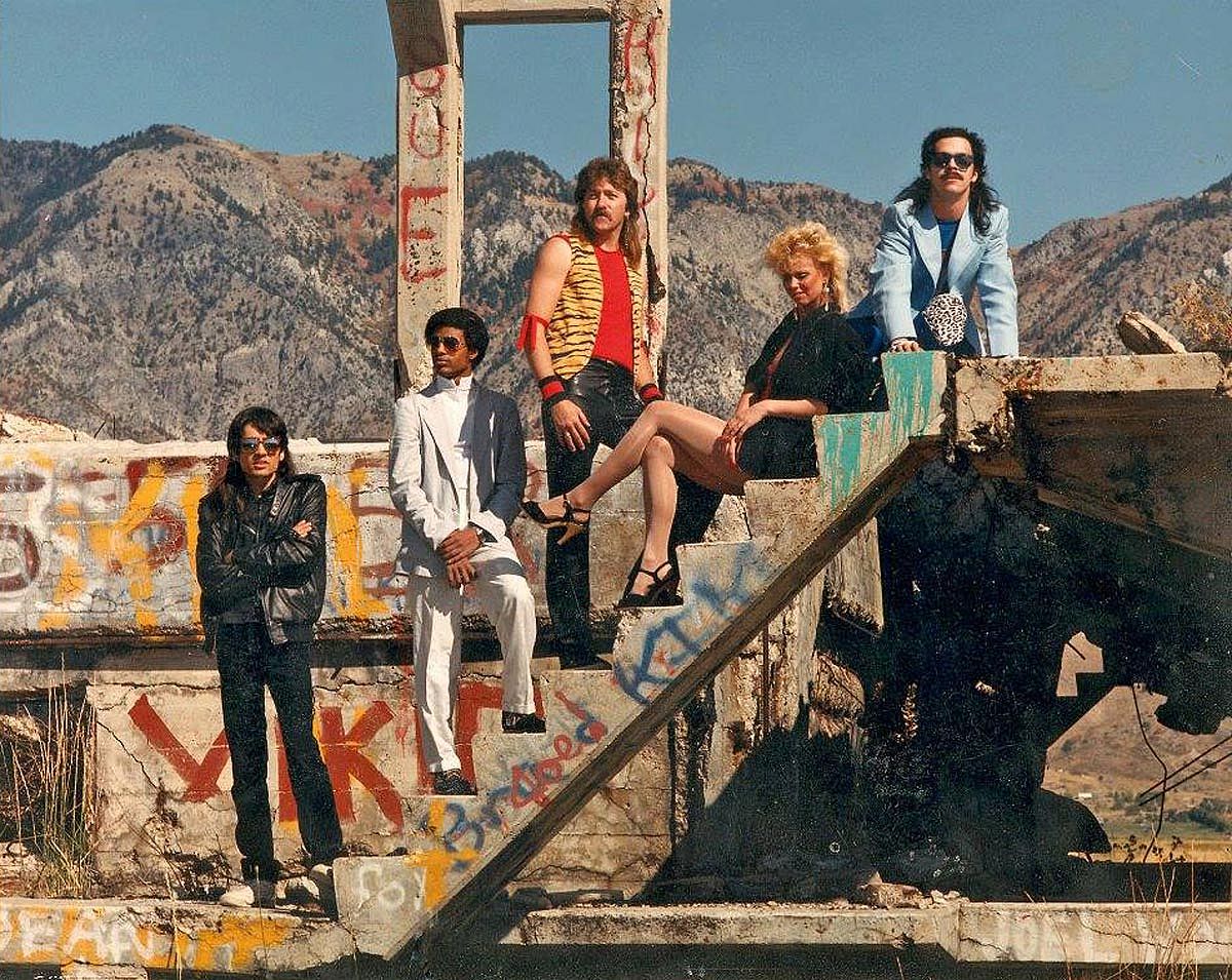 A band of 5 people posing on demolished building for a photoshoot