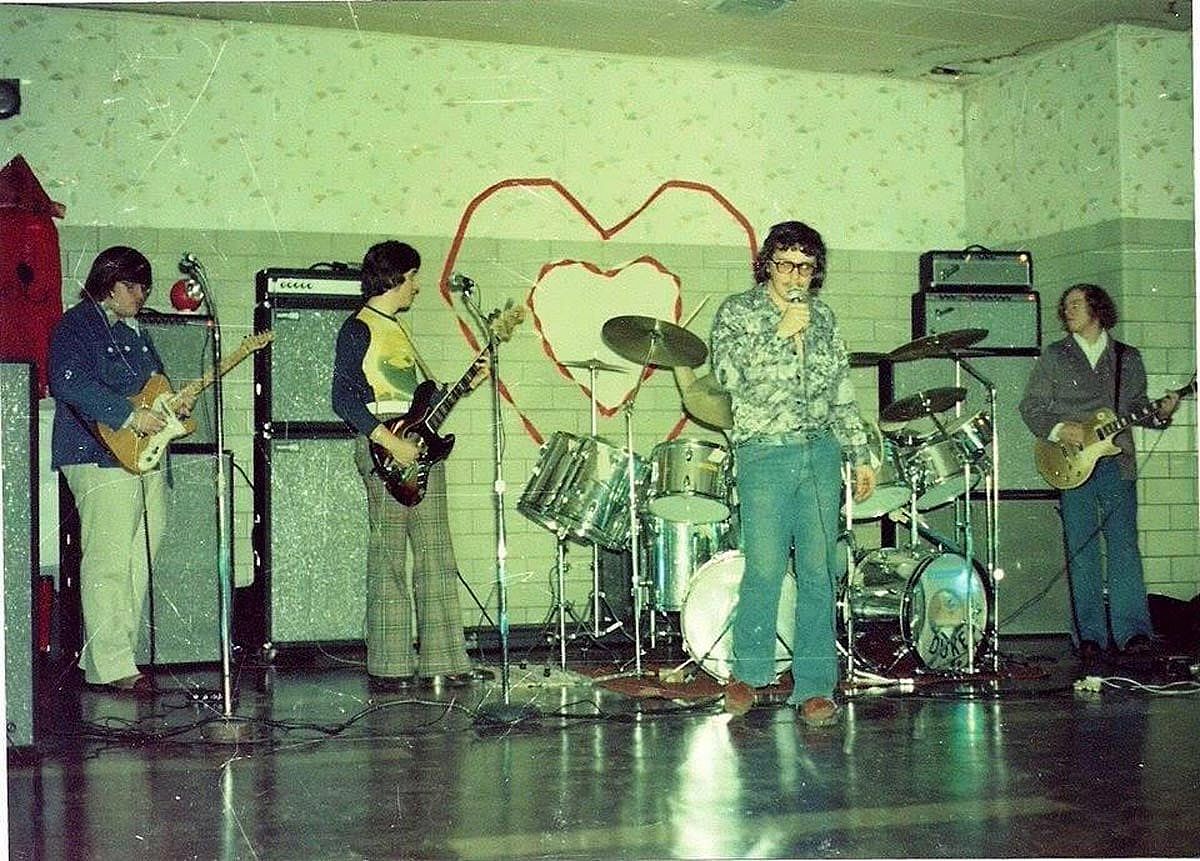 Four guys performing in a band at a school dance