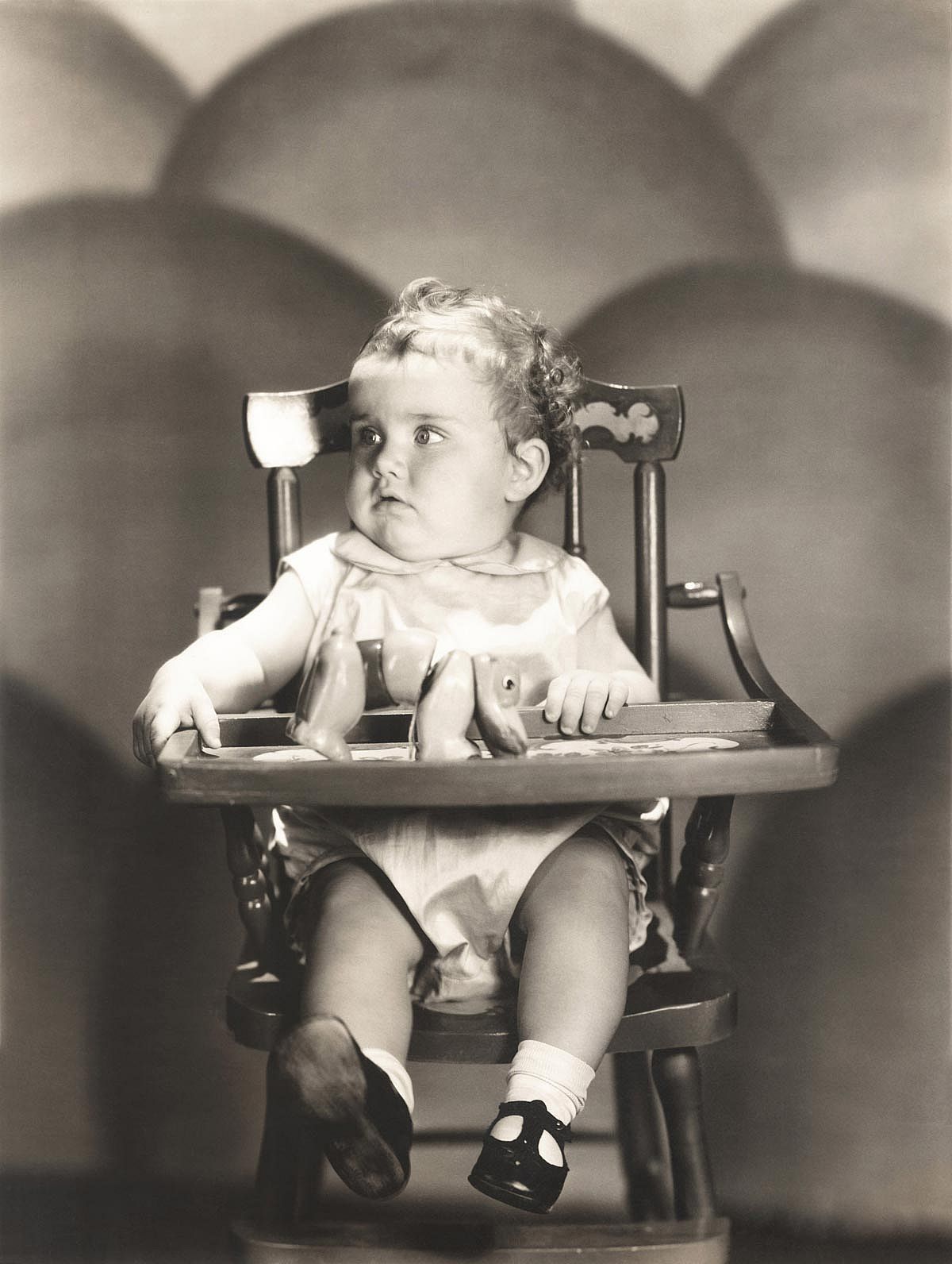 Baby in the 1940s sitting in a high chair