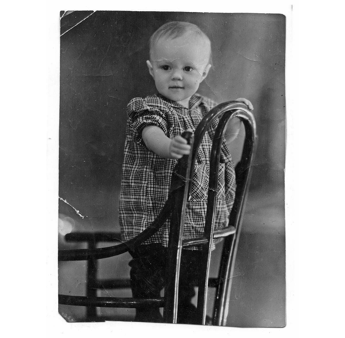 Portrait of an child in the 1940s standing on a chair