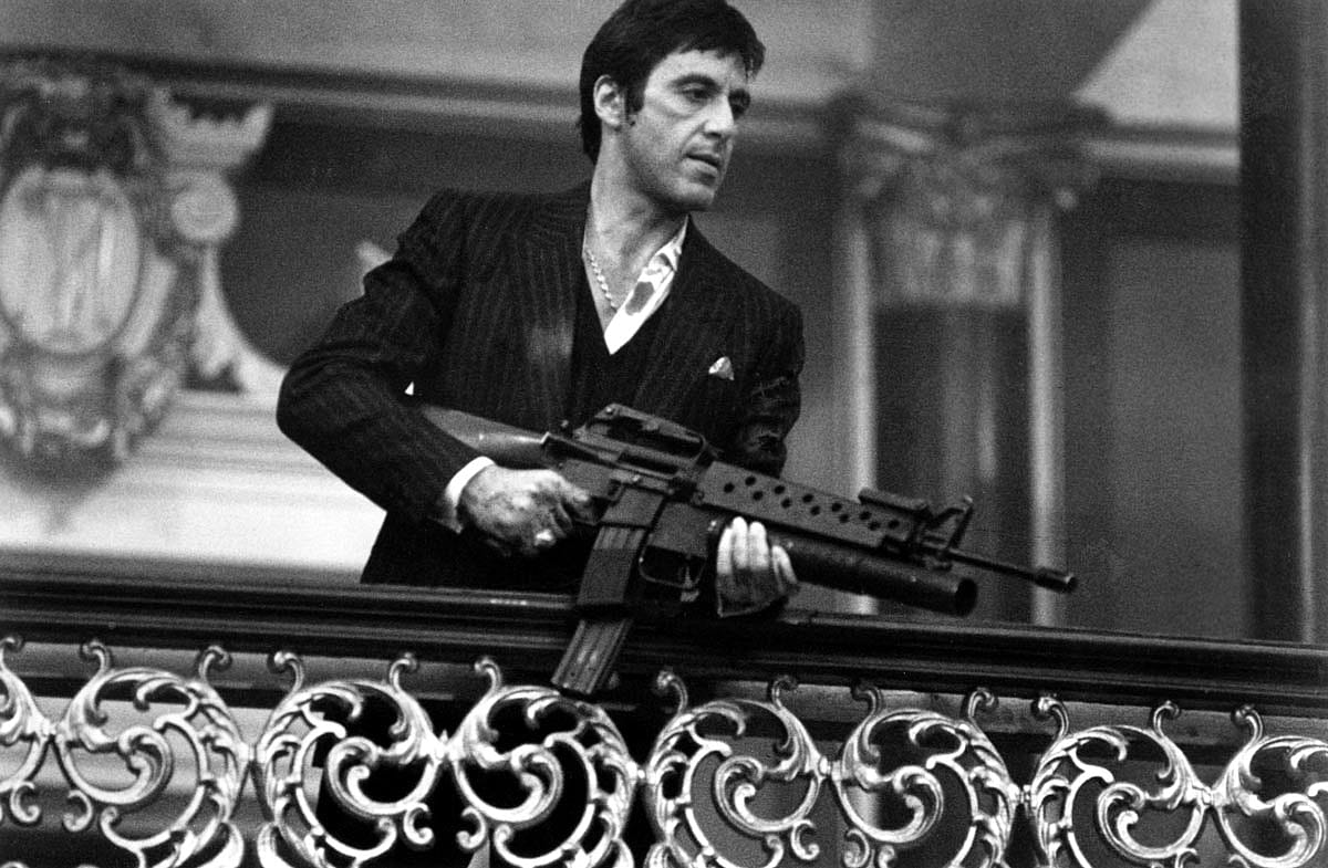 Al Pacino holding an assault rifle in the movie Scarface.