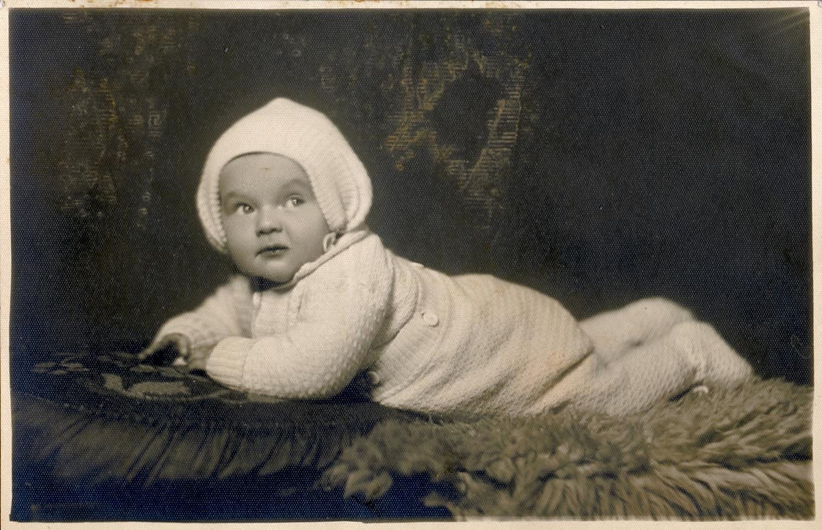 Black and white photo of a baby girl with a bonnet on