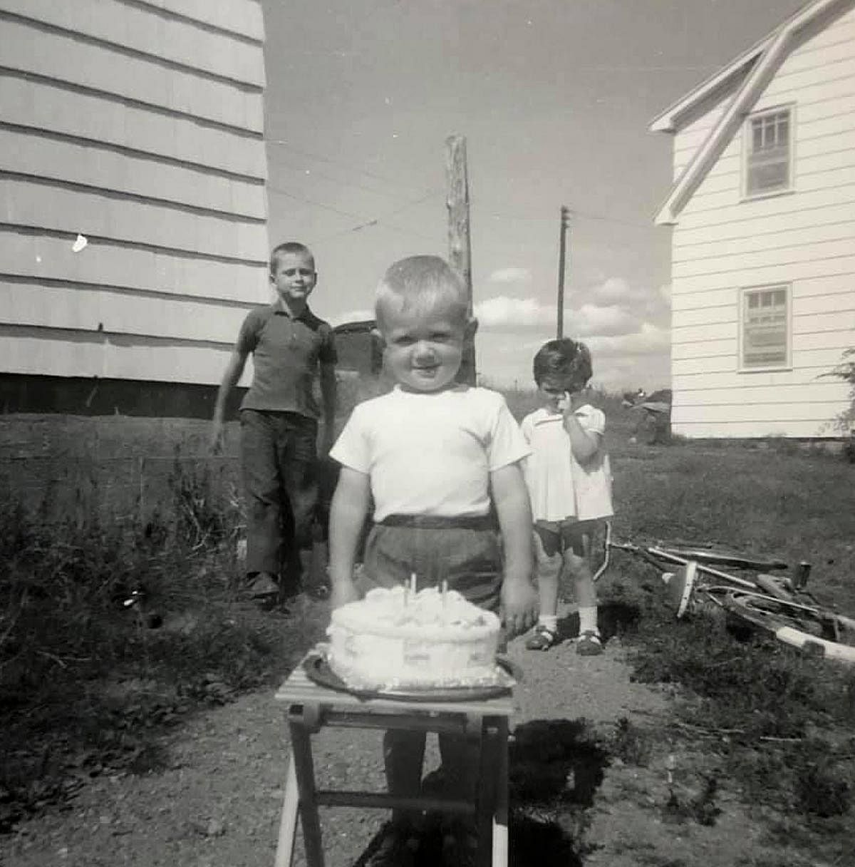 A boy stands behind his birthday cake posing for a picture