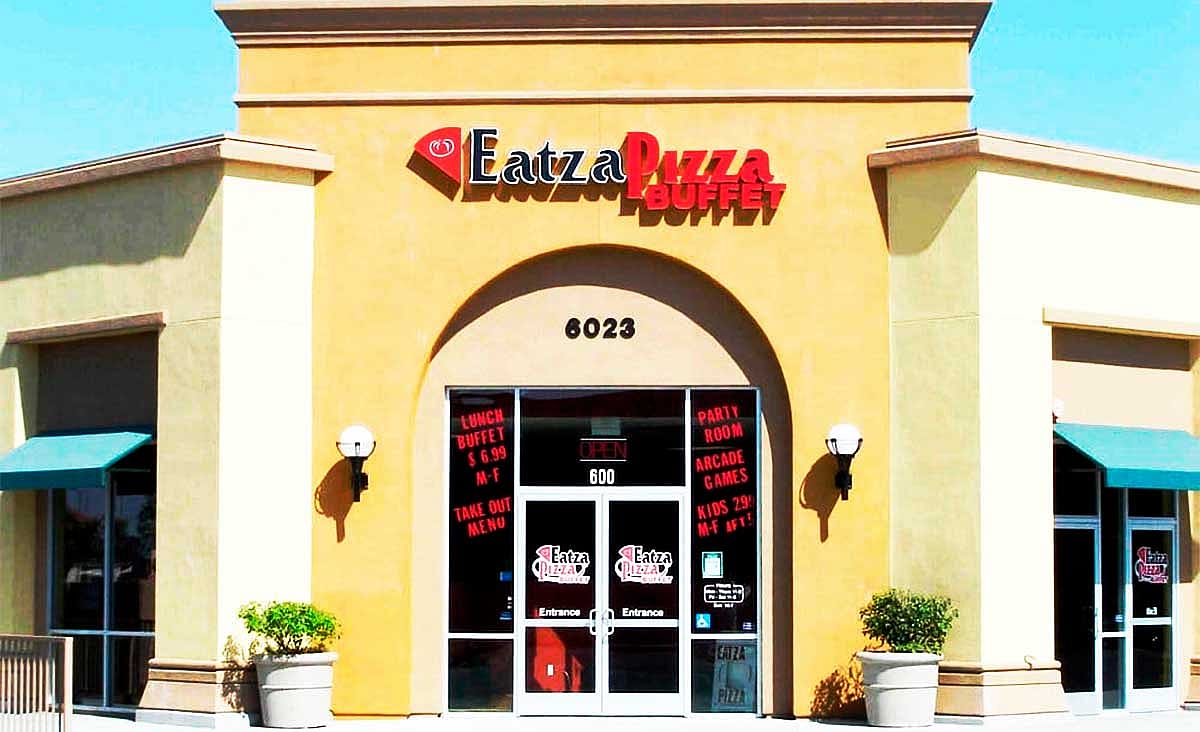 Exterior of an Eatzza Pizza Buffet restaurant with a large arched entrance and the restaurant's sign above the front doors.