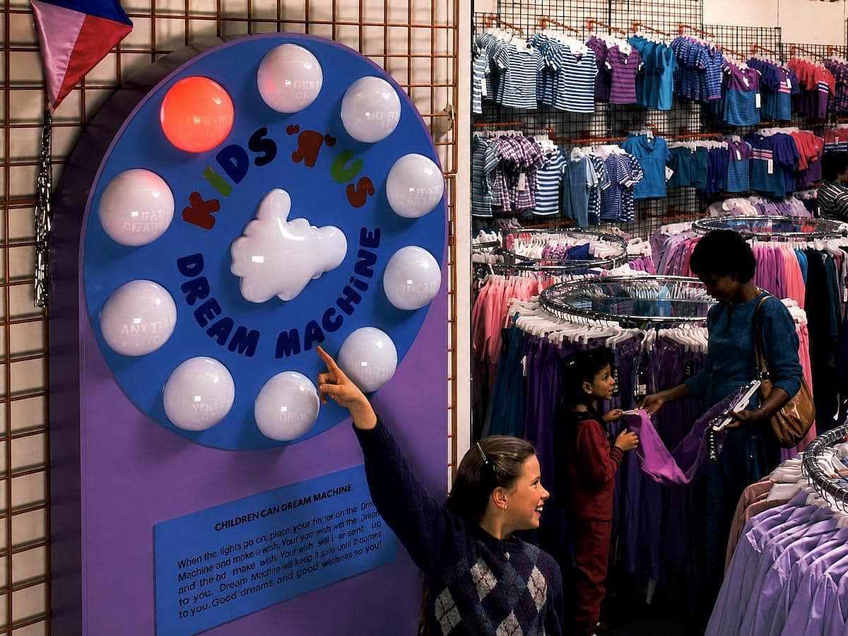 Girl pointing at R machine in clothing store