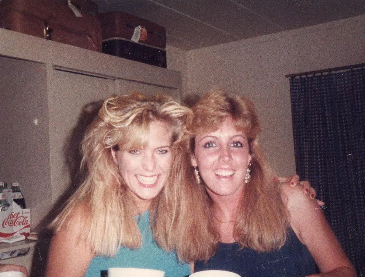 Two women with great 1980s hair smiling for the camera.