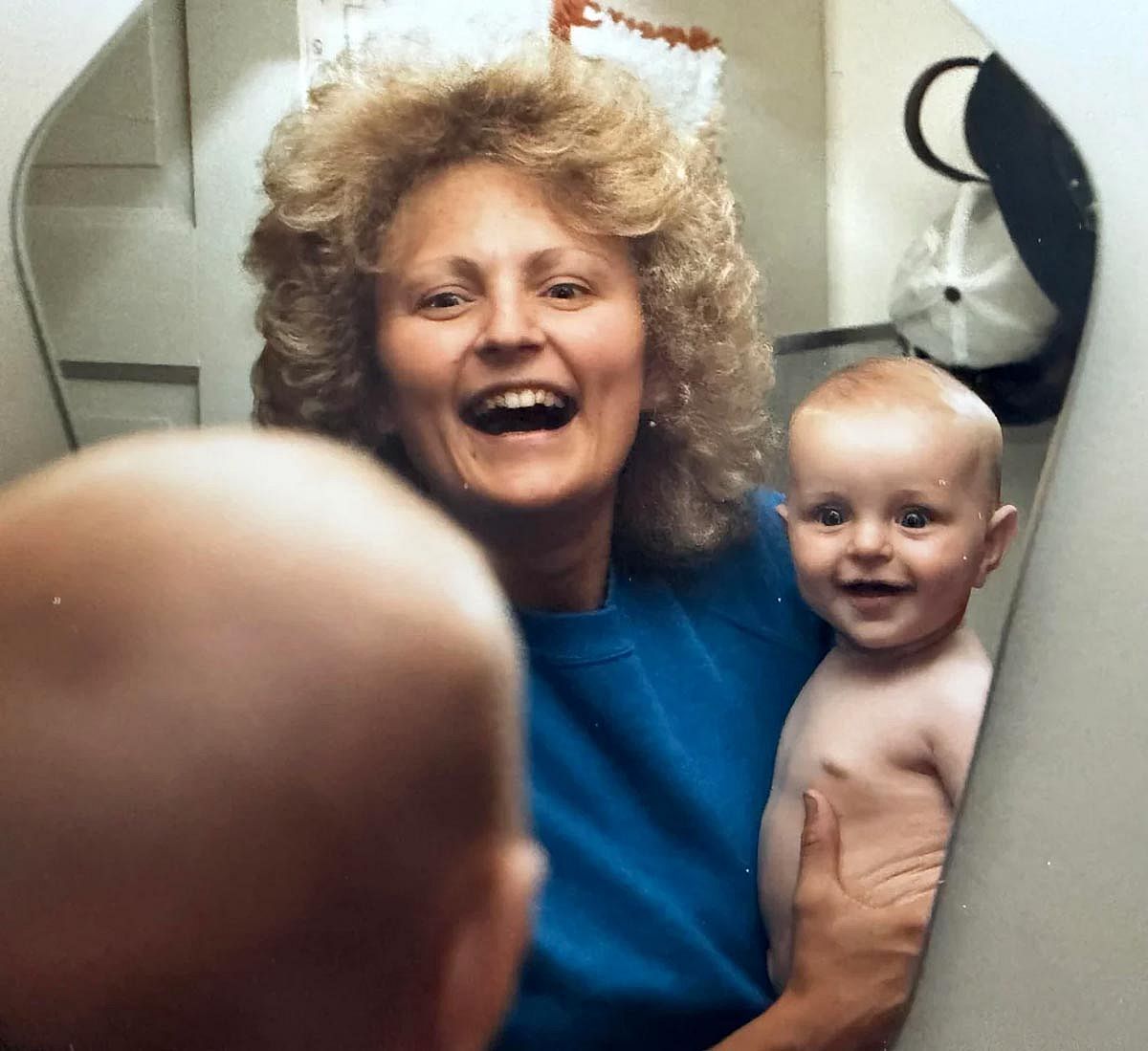 Mama and her baby looking themselves at the mirror