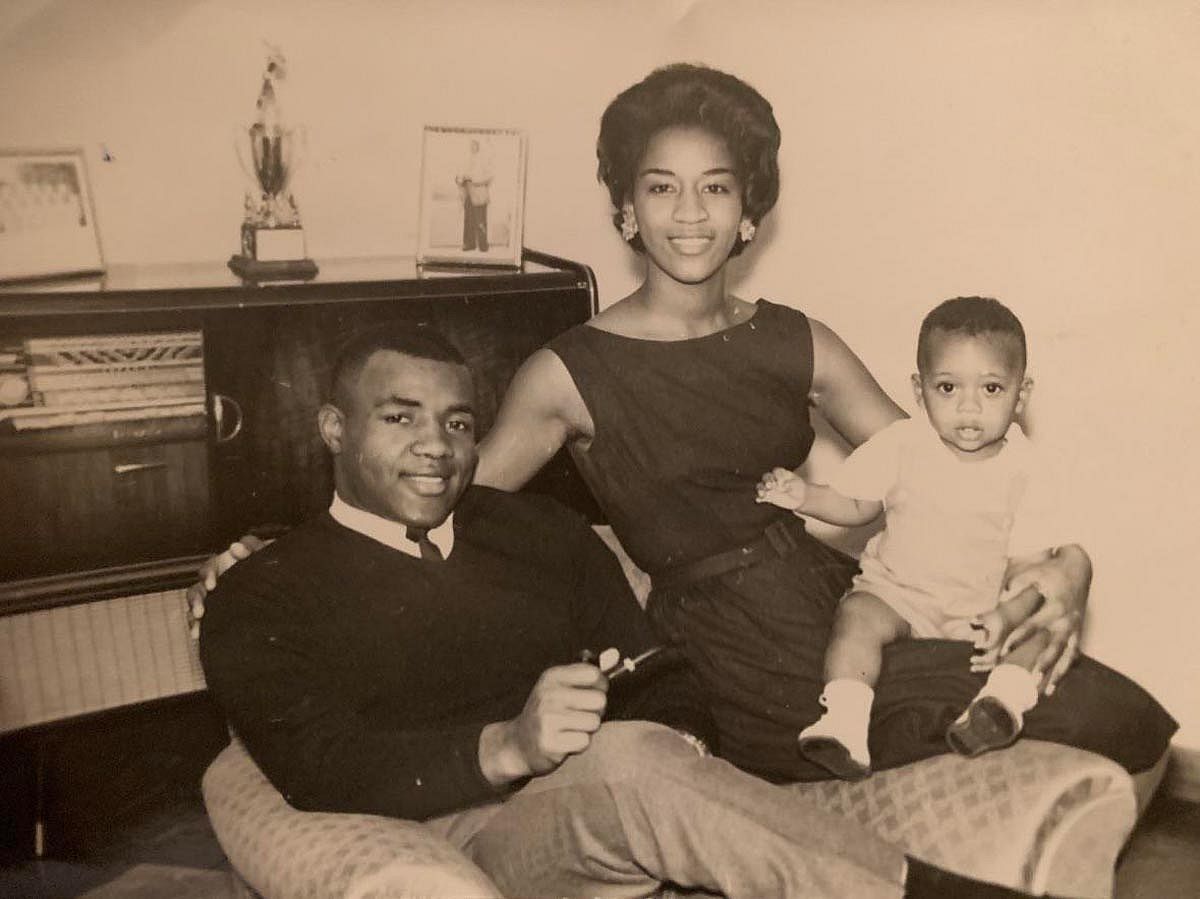 Black and white photo of a family sitting in their home.