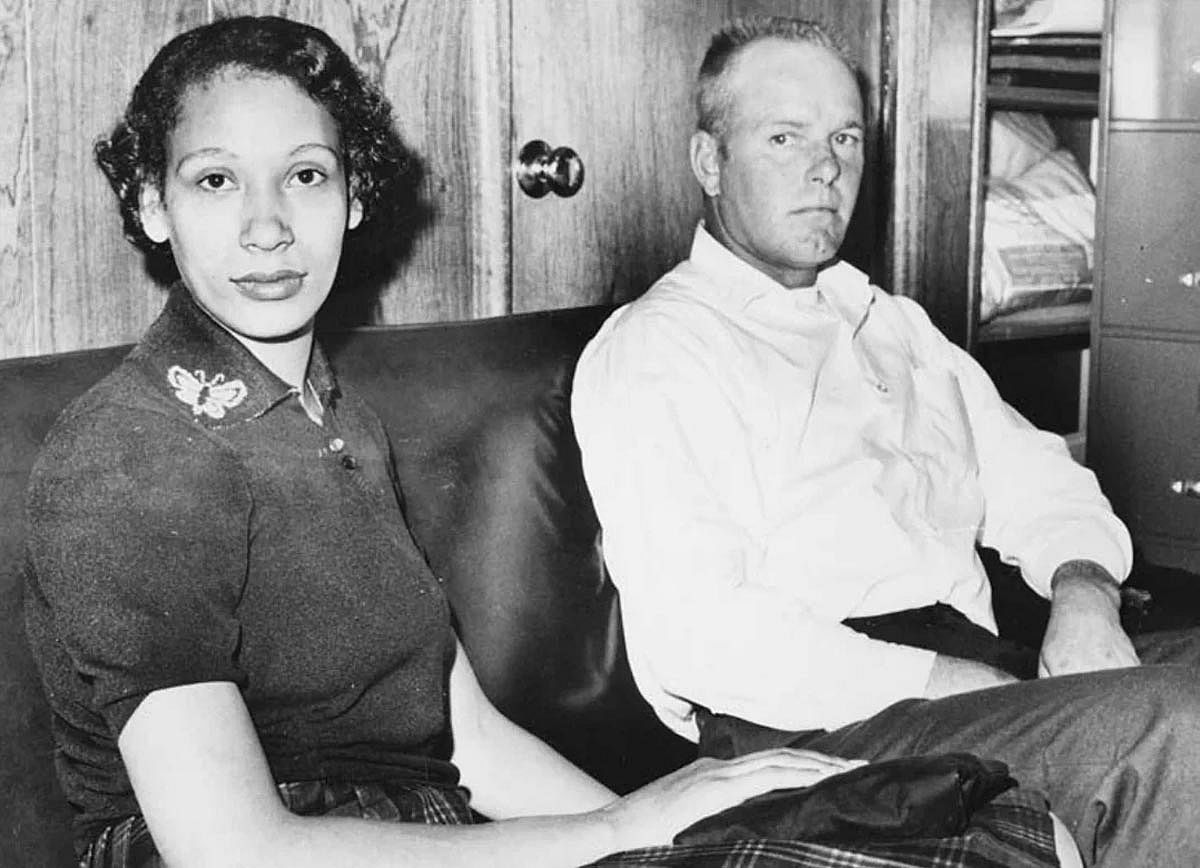 Black and white photo of Richard and Mildred Loving sitting on a couch.