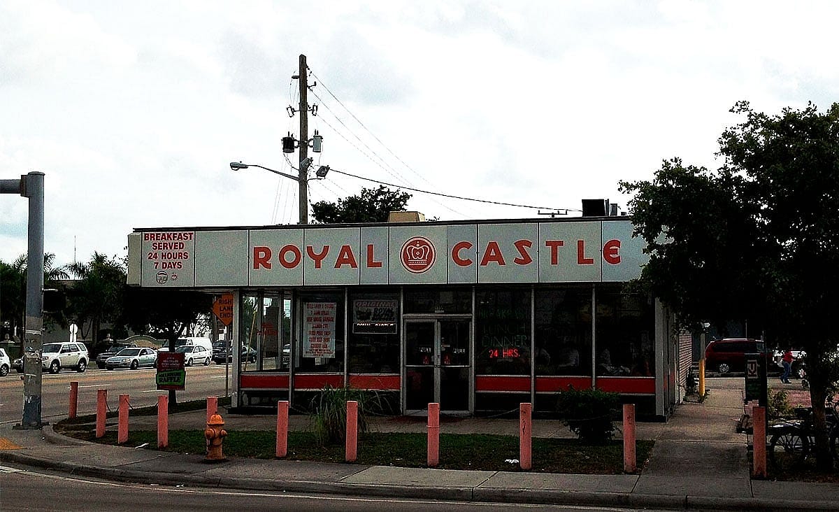 Exterior of a Royal Castle fast-food restaurant on a street corner with retro signage advertising 24-hour service.