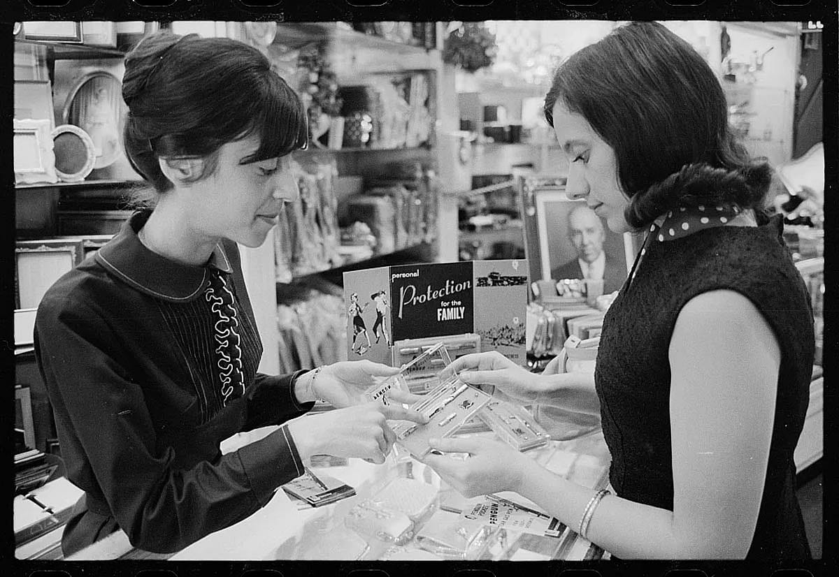 Black and white photo of a saleswoman selling a personal protection device.