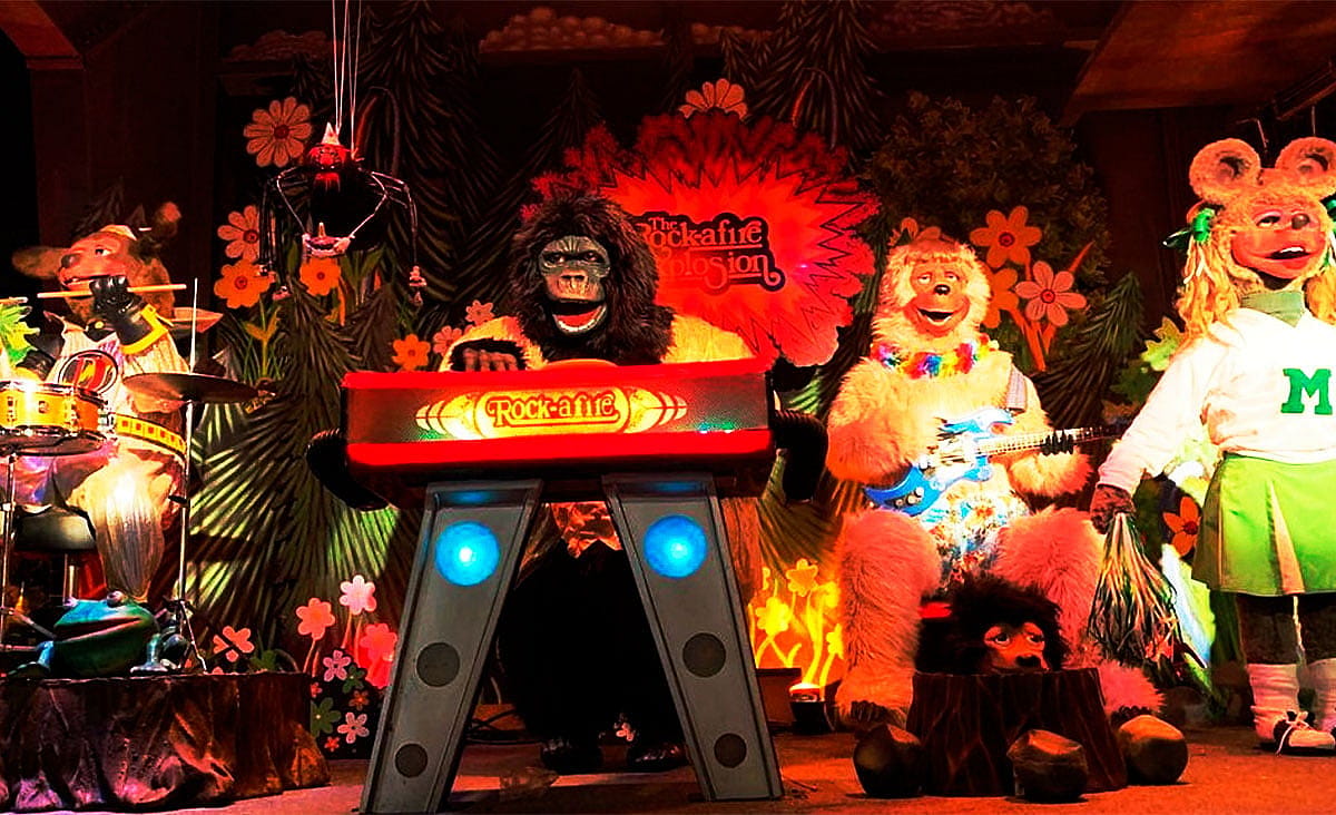 Animatronic animal band performing on stage at a ShowBiz Pizza Place, featuring the Rock-afire Explosion characters.