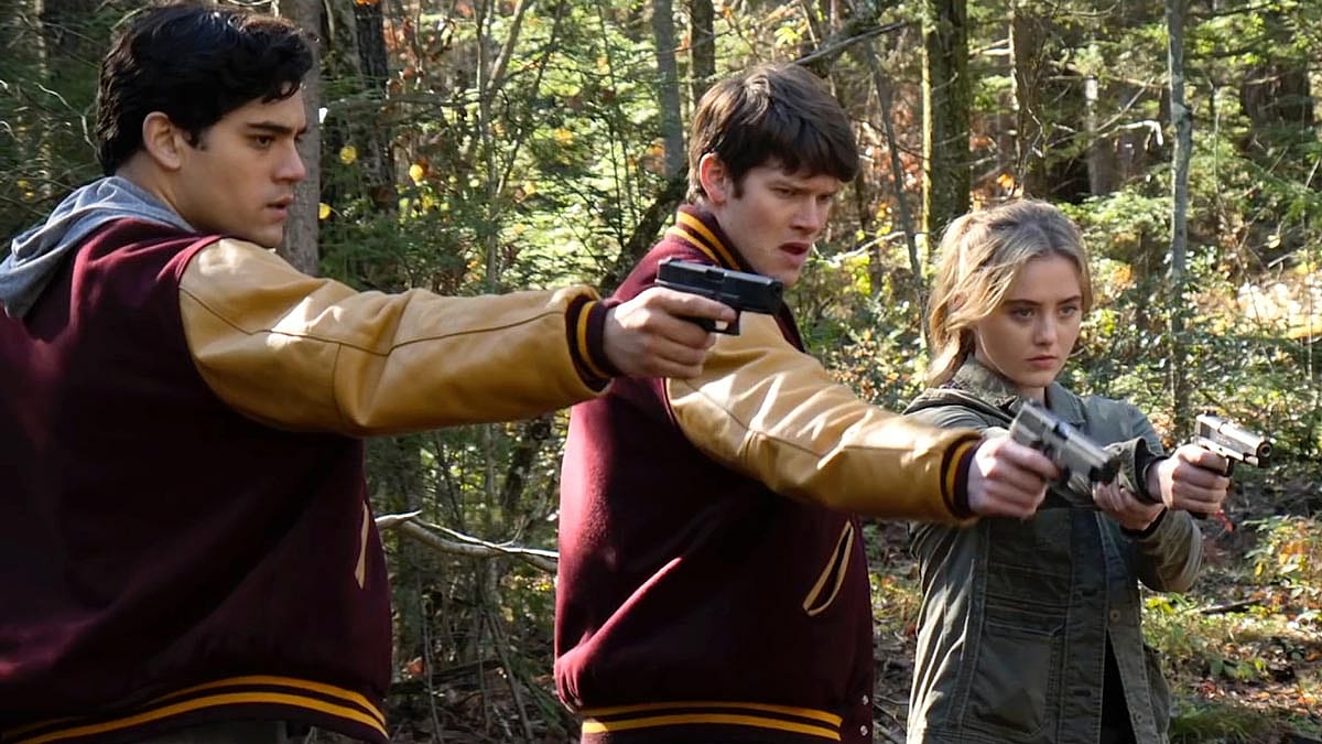 Still from the trailer for The Society where three teens are pointing handguns.