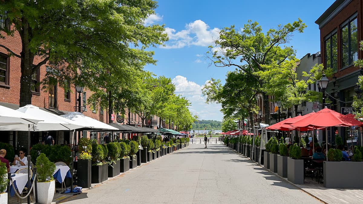 People dining at outdoor tables outside restaurants on King Street, which is the town's main street.
