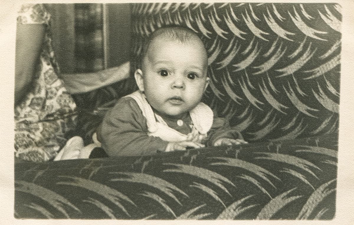 KIEV, USSR - CIRCA 1963: Retro photo of a little baby lying on a sofa