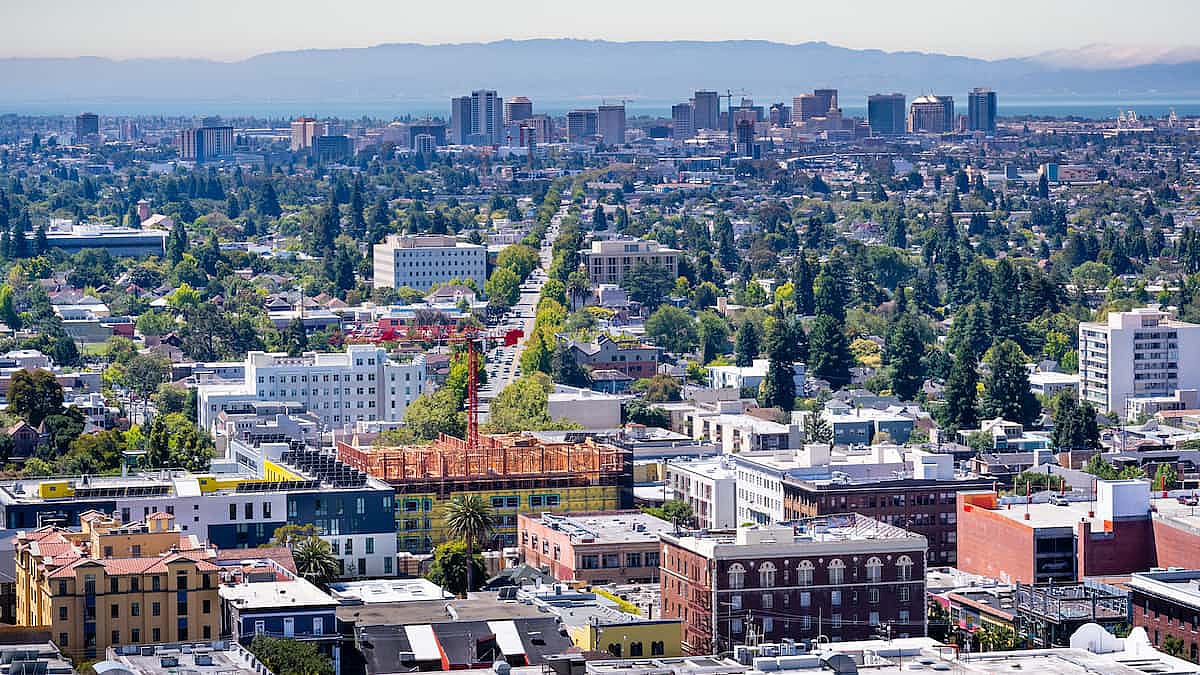 Aerial view of Berkeley and north Oakland on a sunny day; downtown Oakland in the background.