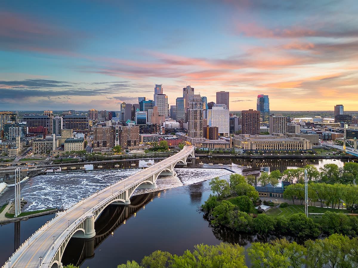 Minneapolis, Minnesota, USA downtown city skyline over the river at dusk.