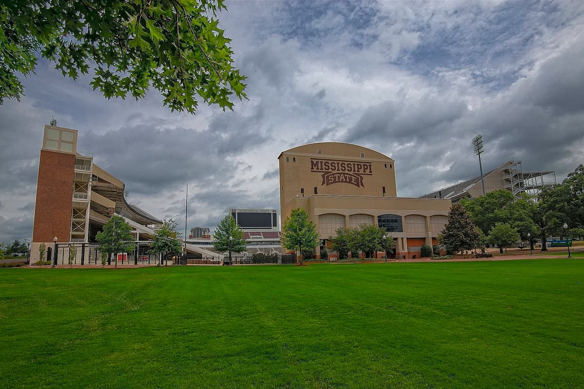 Davis Wade Stadium. Davis Wade Stadium stands tall in Starkville, Mississippi, surrounded by green grass and trees. The sky is overcast as the iconic venue awaits football season.