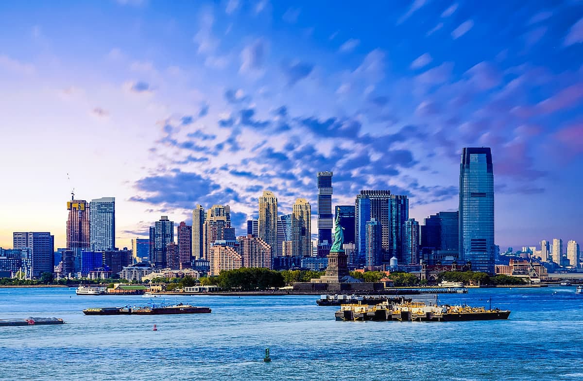 The skyline of Jersey City, New Jersey from New York Harbor with the Statue of Liberty in the foreground
