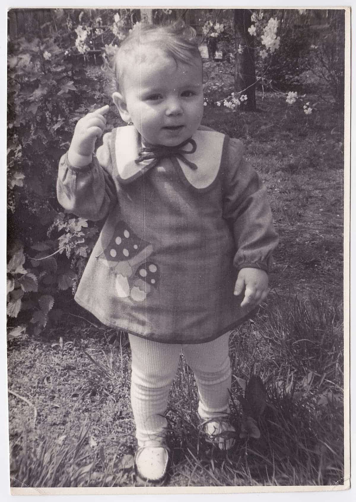 A vintage close-up photograph of a sweet little girl outdoors. 