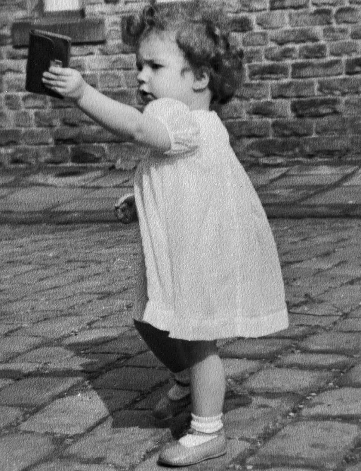 Vintage Black and White photo of a little girl holding a wallet.