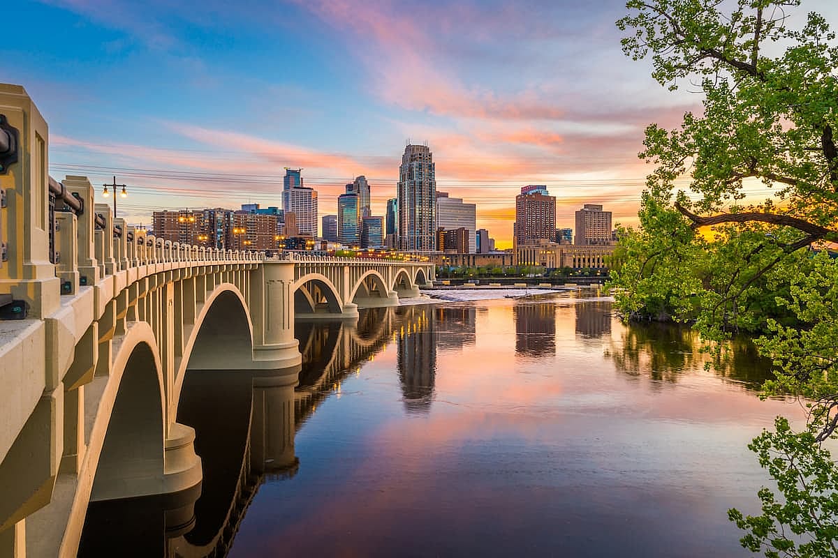 Minneapolis, Minnesota, USA downtown skyline on the Mississippi River with the Third Avenue Bridge at twilight.