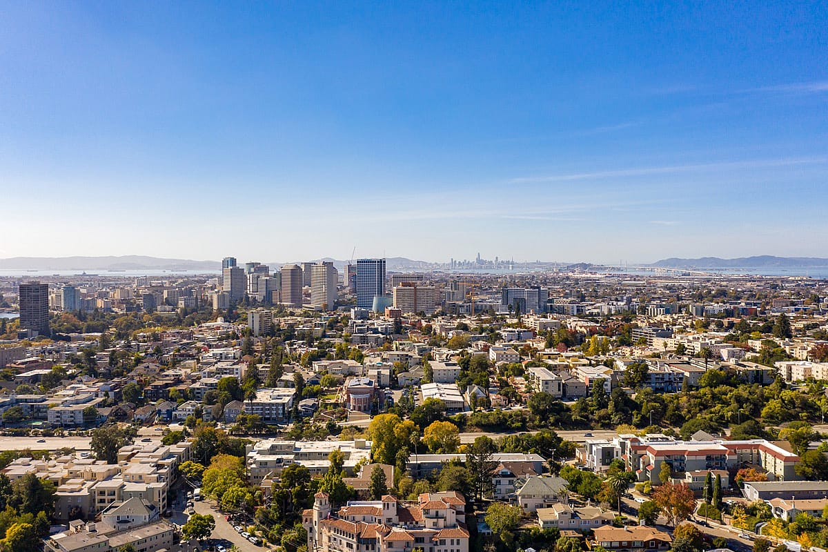 Drone photo over the City of Oakland with San Francisco and the Bay Bridge in the background.