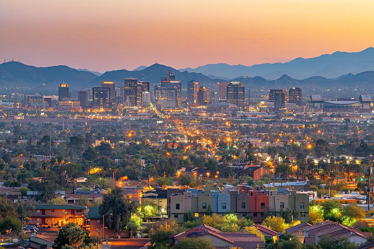 An arial cityscape of downtown Phoenix, Arizona at dusk.