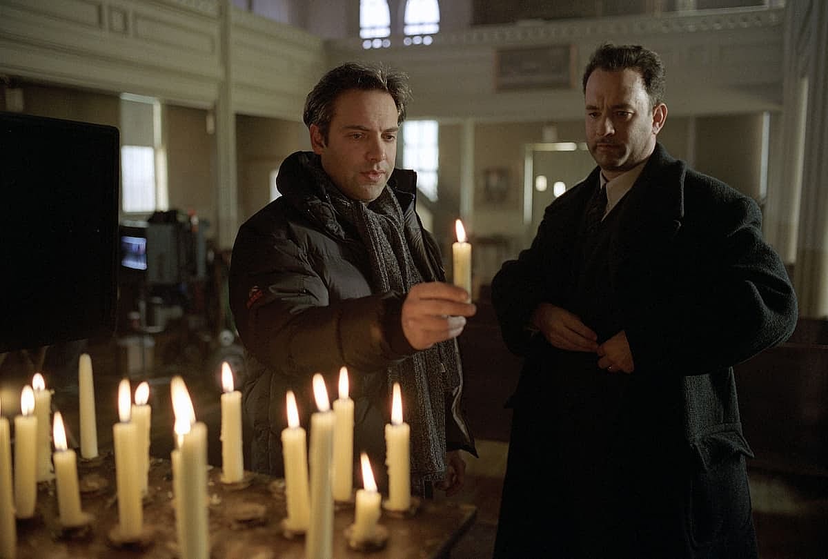 Tom Hanks and Sam Mendes holding candles in A Road to Perdition.