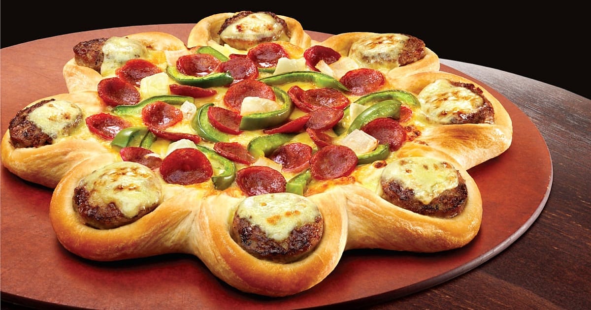 Pizza topped with pepperoni, green peppers, and pineapple, with mini cheeseburgers baked into the crust.