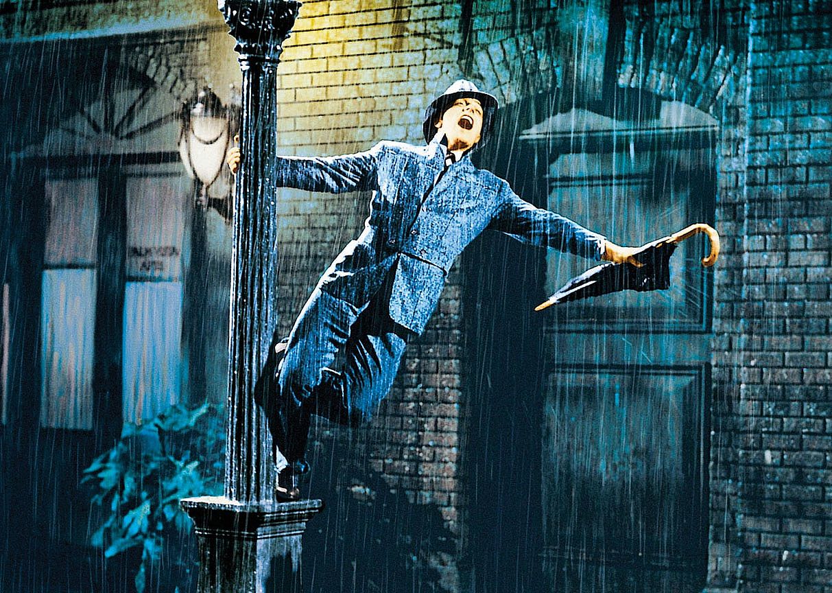 Gene Kelly dances in the rain on a lamppost.