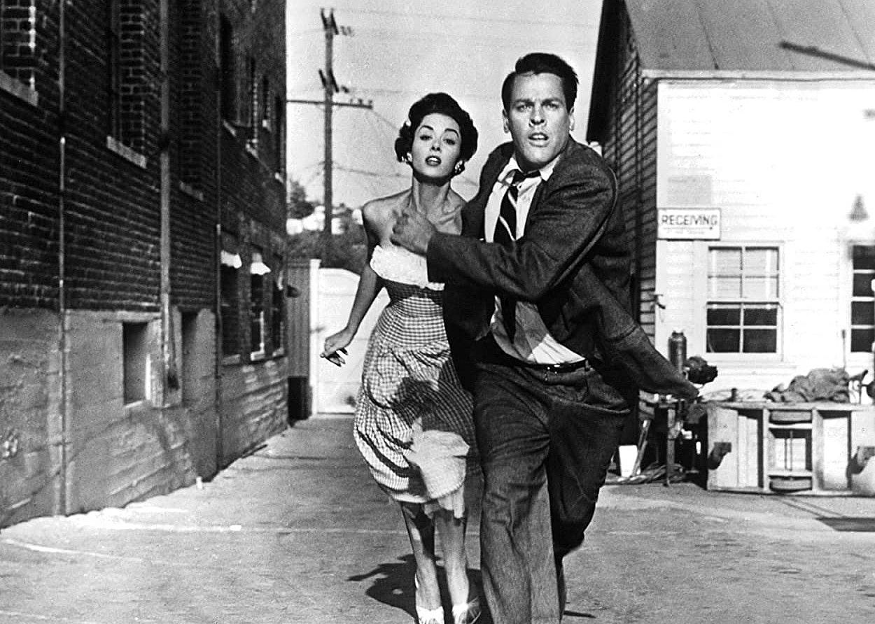 A man and woman dressed up and running for their lives.