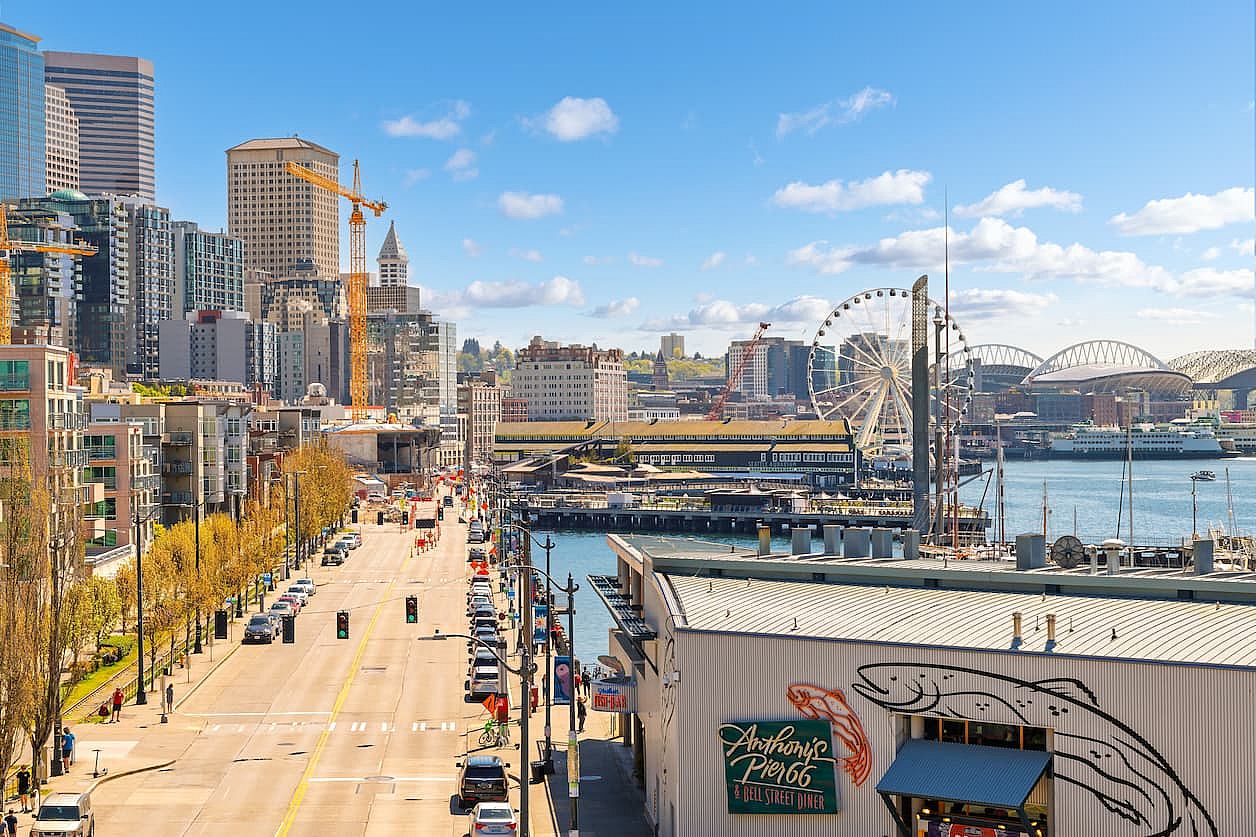 Seattle, Washington USA - May 3 2025: View of Alaska Way, the main street along the Seattle Waterfront area near Pikes Place market, with the Great Ferris Wheel and Safeco Field in view.