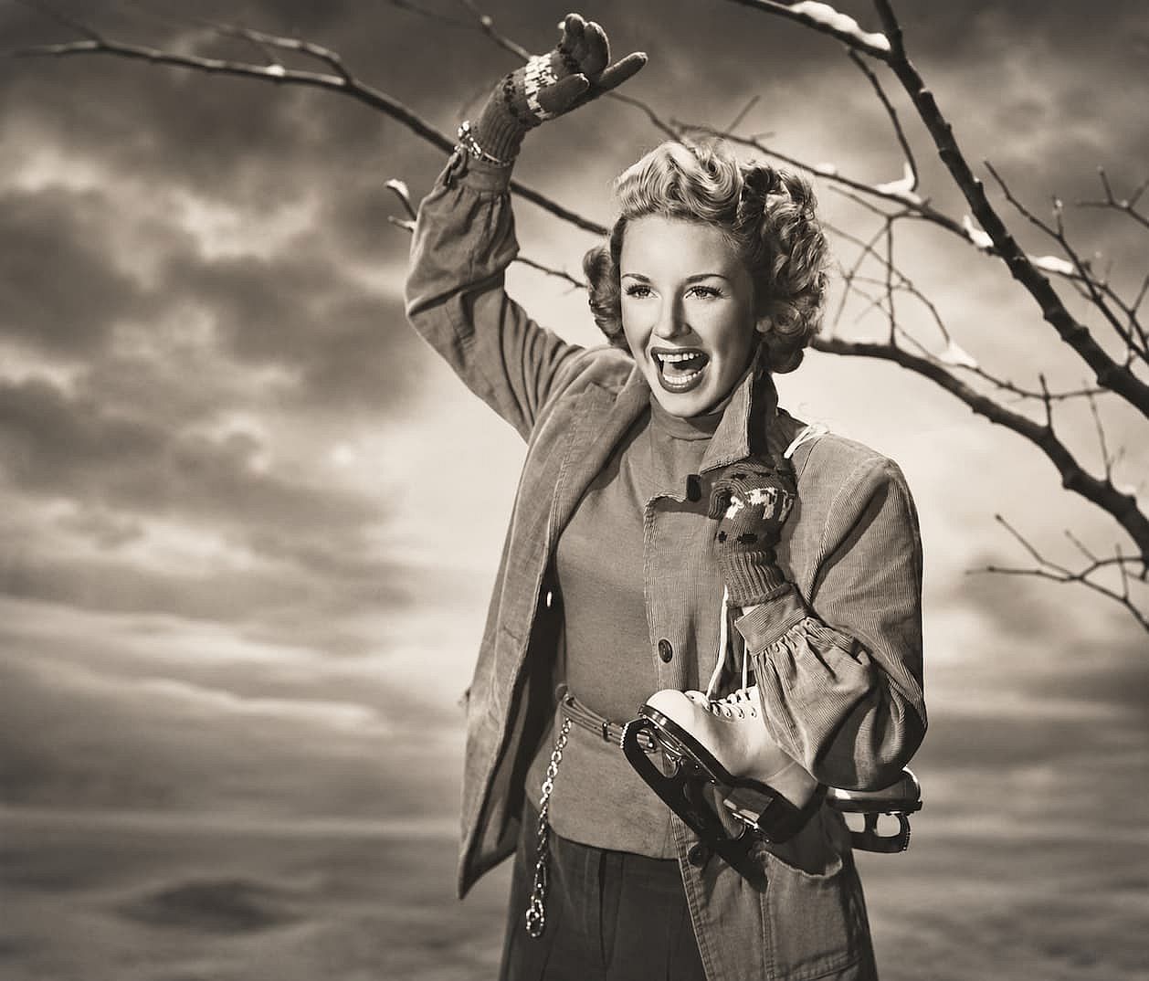 Happy woman carrying ice skates