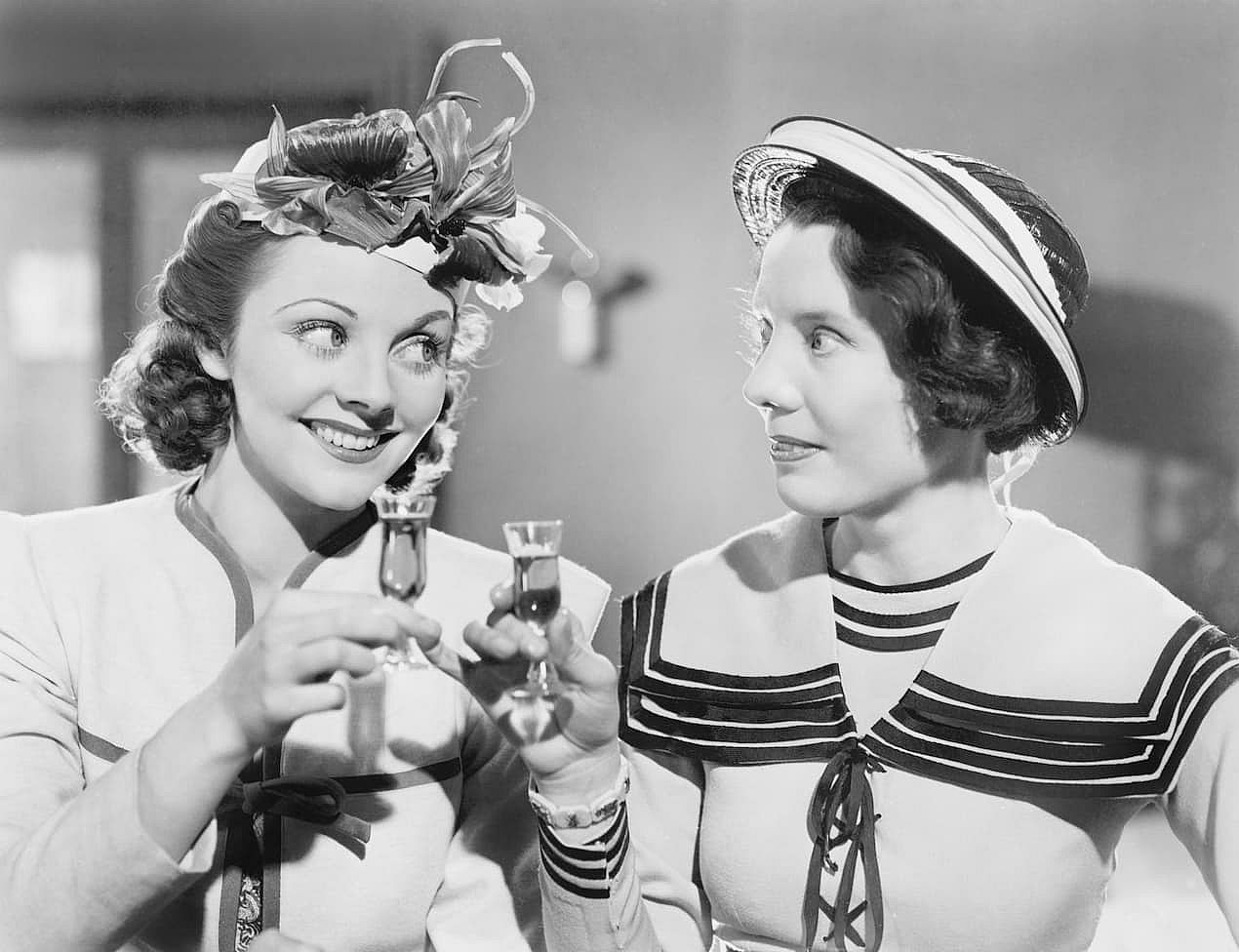 Two women drinking a schnapps congratulating each other.