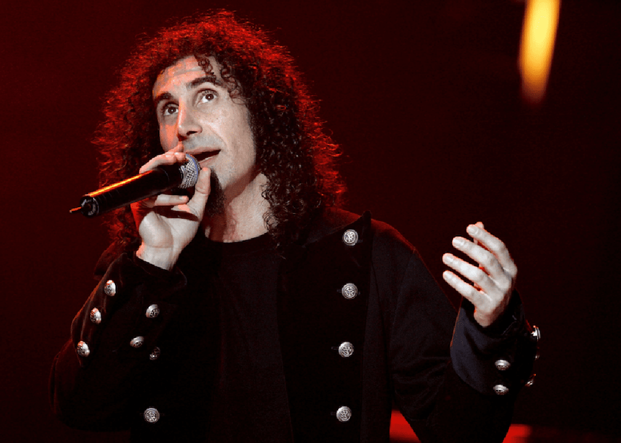 Serj Tankian speaks with microphone.