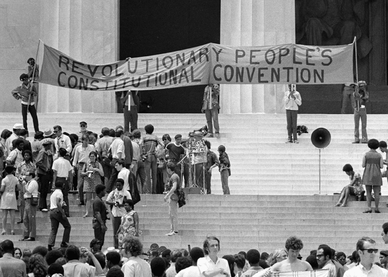 Crowds gather outside the Lincoln Memorial as a banner is unfurled that reads Revolutionary People's Constitutional Convention.