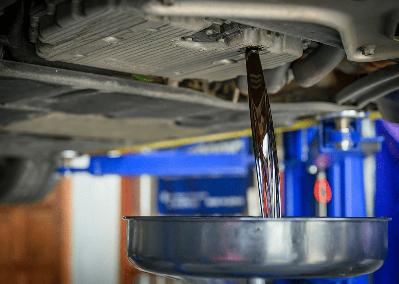 Transmission fluid draining from car into a metal funnel.