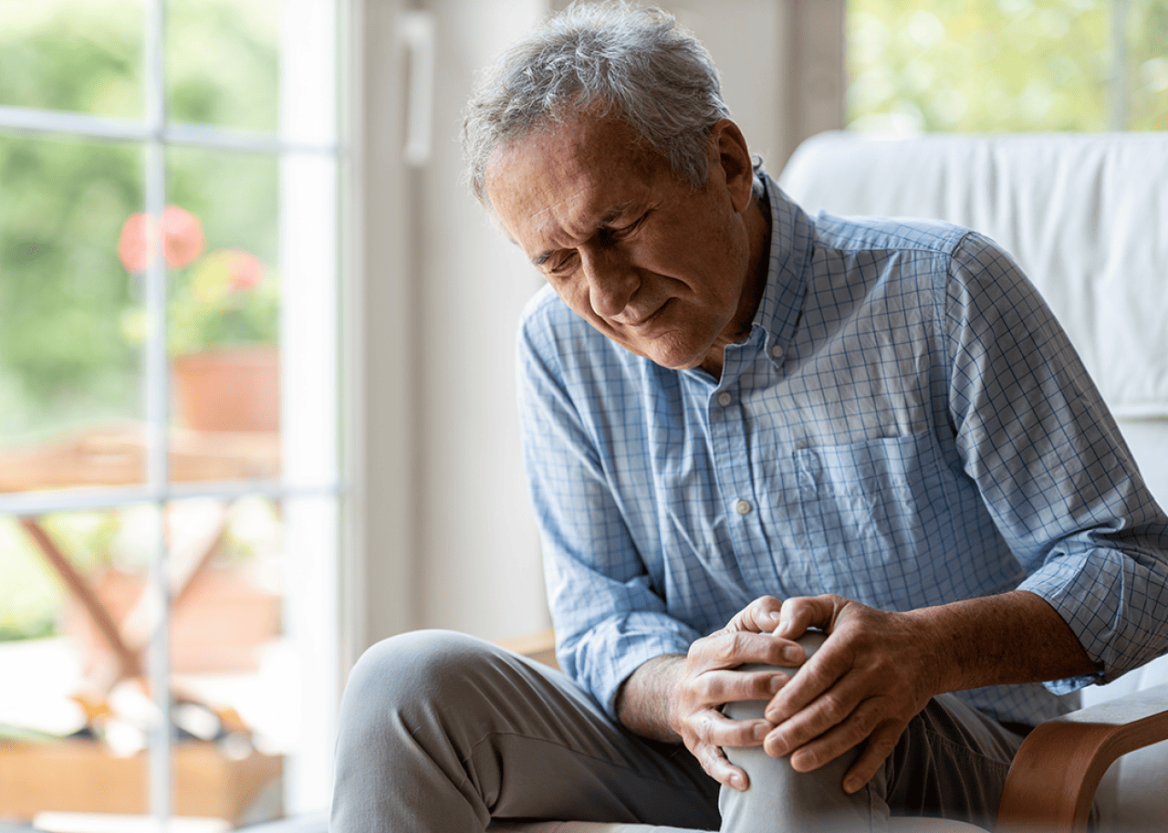 Older man holding knee.