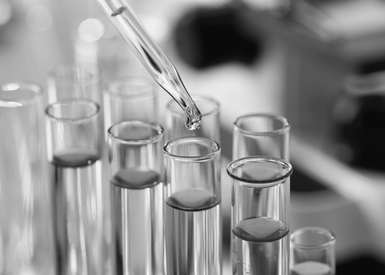 Dripping liquid from pipette into test tube in laboratory,
