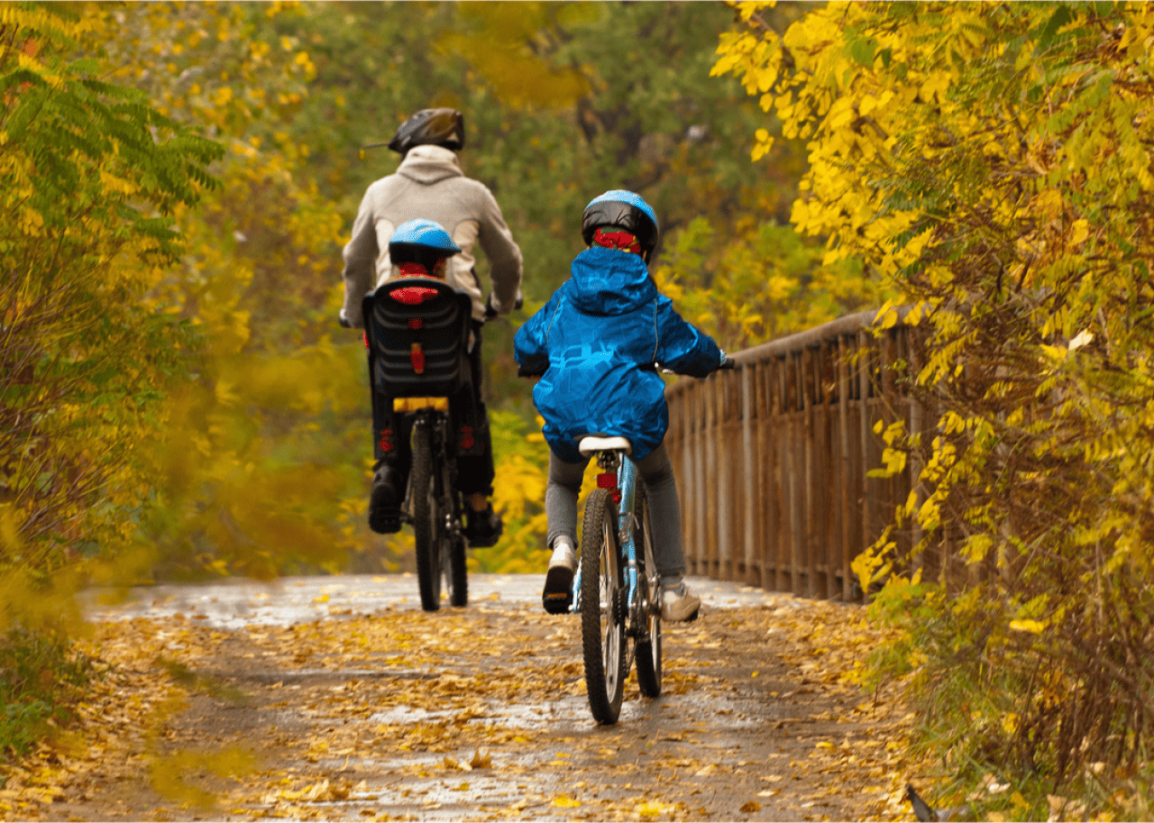 Family riding on bike path in autumn.