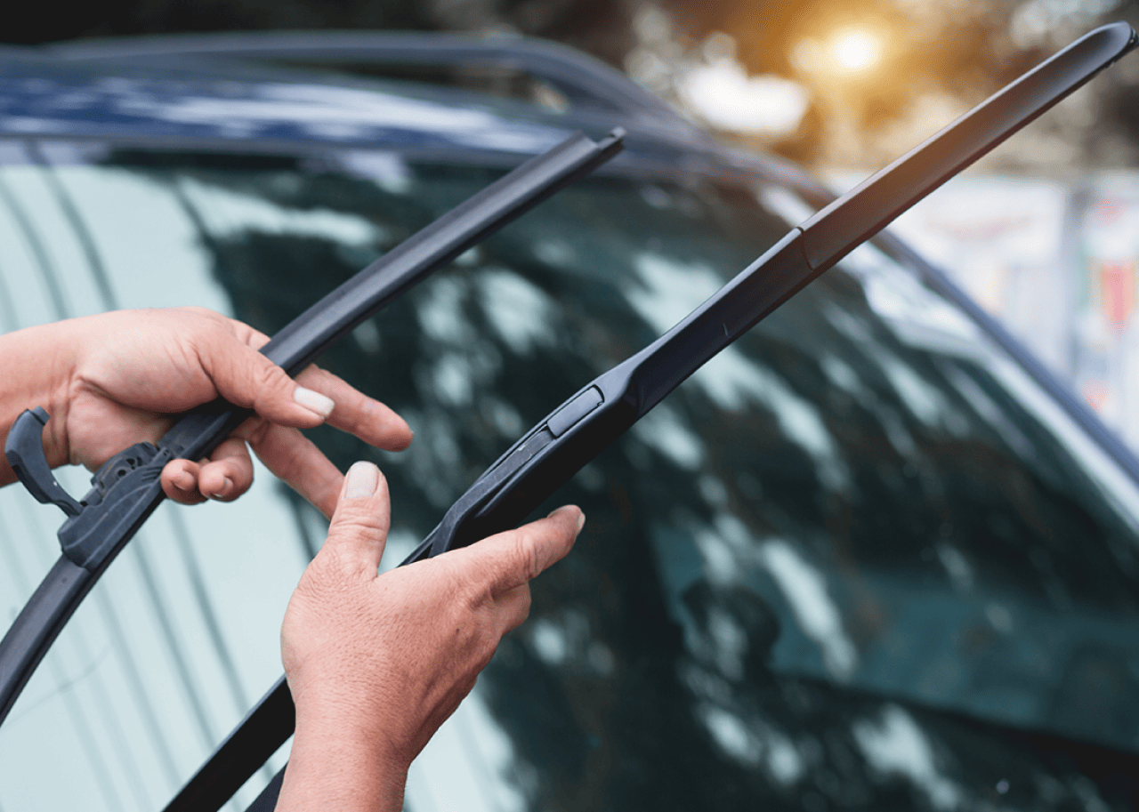 Hands replacing windshield wipers.