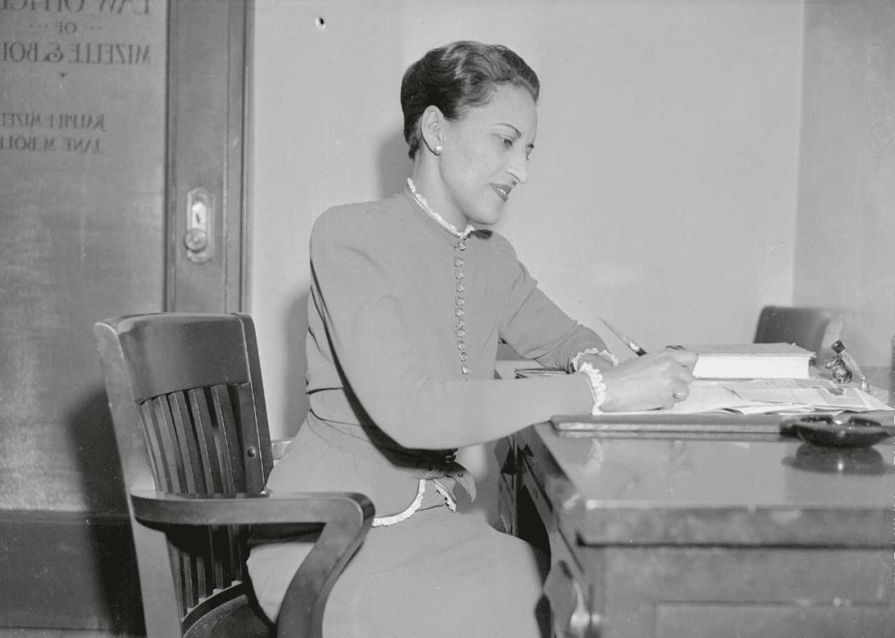 Jane Bolin seated at desk.