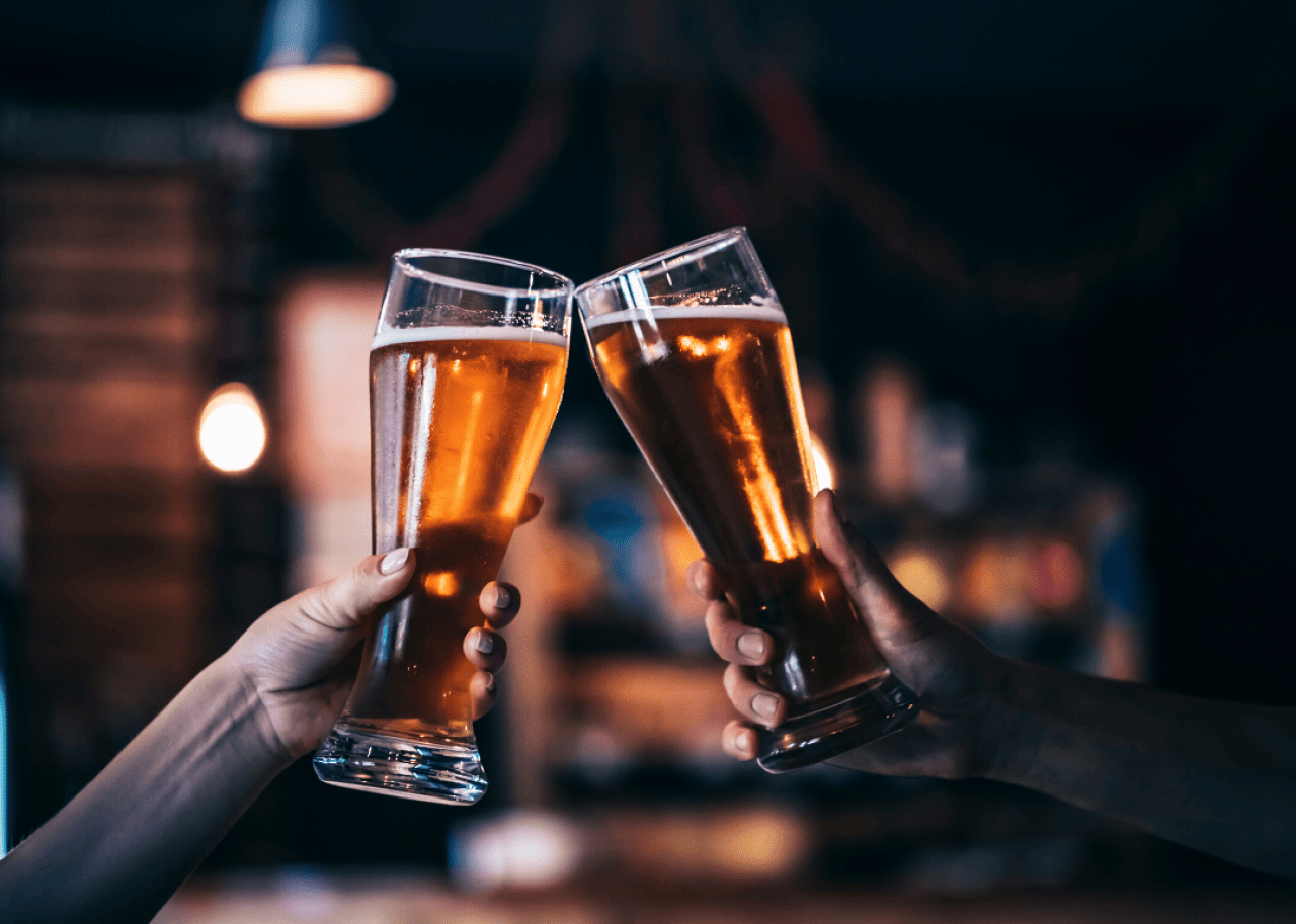 A toast is made with glasses filled with beer.