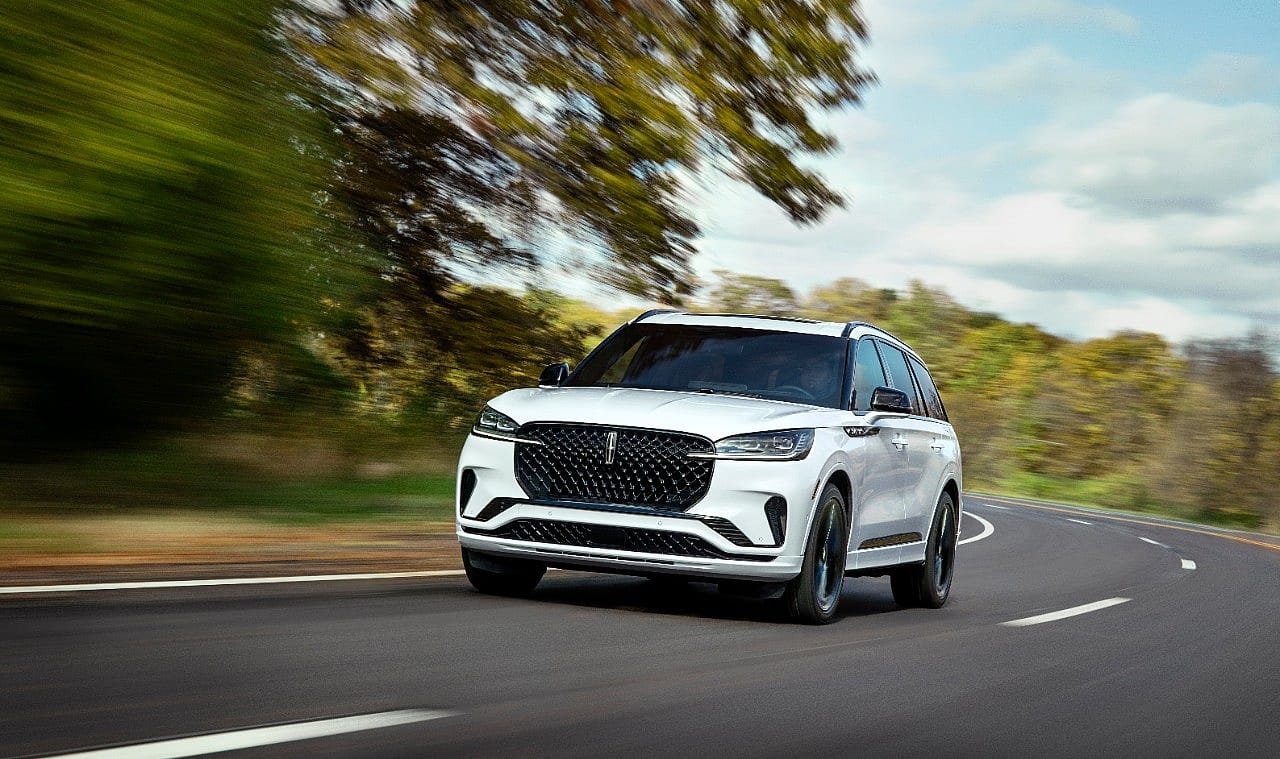 White Lincoln Aviator driving on road.