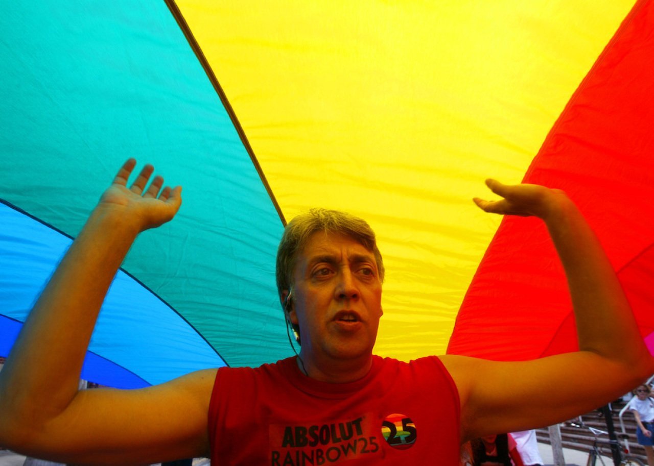 The creator of the first-ever rainbow flag twenty-five years ago, Gilbert Baker, helps stretch the mile and quarter long 